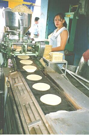 Aqui vemos uma mquina de fazer tortilhas. Uma panqueca feita de milho.